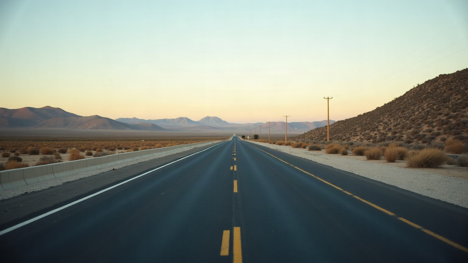 An empty road at dawn running through dry country
